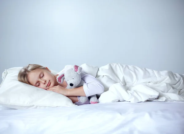 Малышка спит в кровати с игрушечным плюшевым мишкой — стоковое фото