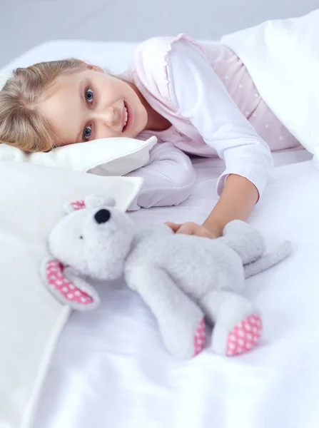 Gyermek kislány alszik az ágyban, egy játék mackó — Stock Fotó