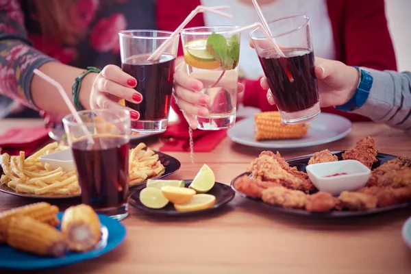 Bovenaanzicht van een groep mensen die samen dineren terwijl ze aan houten tafel zitten. Eten op tafel. Mensen eten fastfood. — Stockfoto