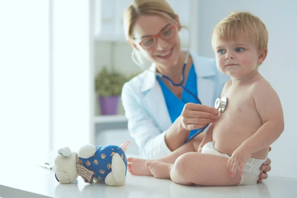 Vrouwelijke arts luistert kind met een stethoscoop in de kliniek — Stockfoto