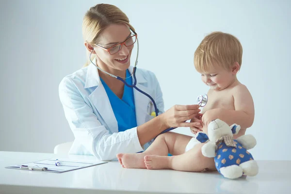 Női orvos hallgat gyerek sztetoszkóppal a klinikán — Stock Fotó