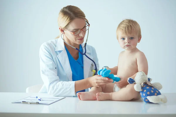 Vrouwelijke arts luistert kind met een stethoscoop in de kliniek — Stockfoto