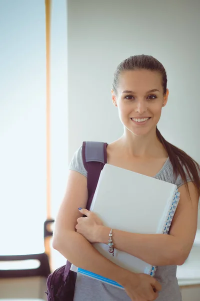 Retrato de una joven estudiante sosteniendo libros de ejercicios. Estudiante mujer — Foto de Stock