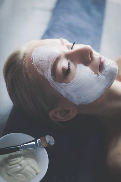 Mascarilla facial. Hermosa joven en el spa, mujer cosmética aplicando mascarilla facial — Foto de Stock