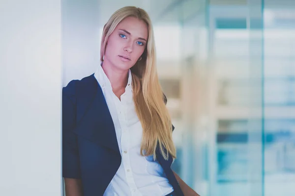 Porträtt av ung affärskvinna i tjänst med kollegor i bakgrunden — Stockfoto