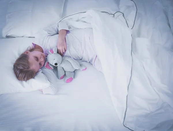Niño niña duerme en la cama con un osito de peluche de juguete — Foto de Stock