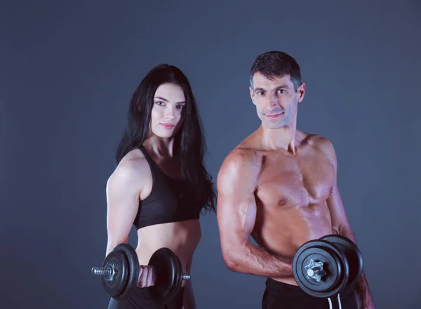 Hombre y mujer atléticos con mancuernas — Foto de Stock