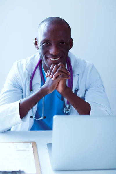 Masada dizüstü bilgisayarda çalışan genç bir Afrikalı doktor. — Stok fotoğraf