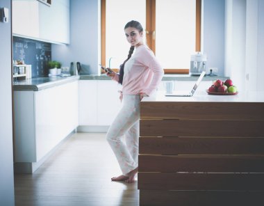 modern mutfakta otururken cep telefonu kullanan kadın