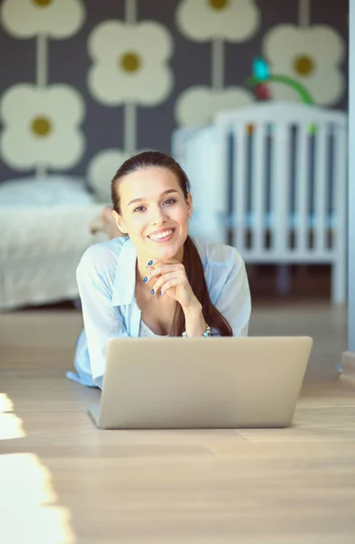 Młoda piękna kobieta w domu siedzi na podłodze z laptopa — Zdjęcie stockowe