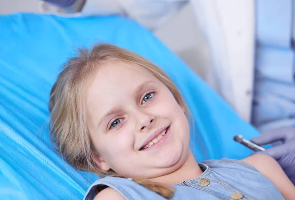 Niña sentada en el consultorio de dentistas —  Fotos de Stock