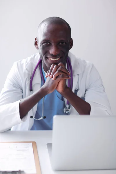 Masada dizüstü bilgisayarda çalışan genç bir Afrikalı doktor. — Stok fotoğraf