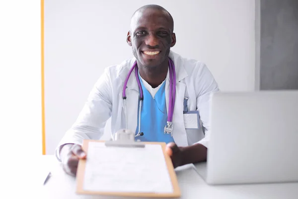Masada dizüstü bilgisayarda çalışan genç bir Afrikalı doktor. — Stok fotoğraf