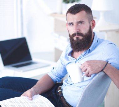 sandalye ile office kitapta oturan genç işadamı