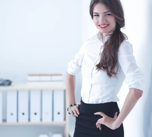 Attraktive Geschäftsfrau steht an Wand im Büro — Stockfoto