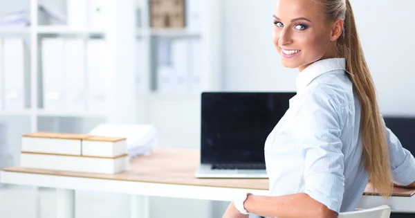 Attraente donna d'affari seduta su una scrivania con computer portatile in ufficio — Foto Stock