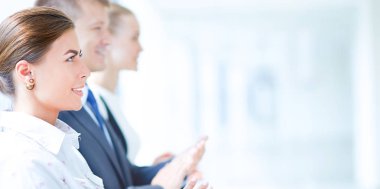 Gülümseyen iş adamları ofiste iyi bir sunumu alkışlıyorlar.