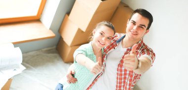 Genç Çift başparmak göstermek yukarıya onların yeni modern tasarım evinde mutlu