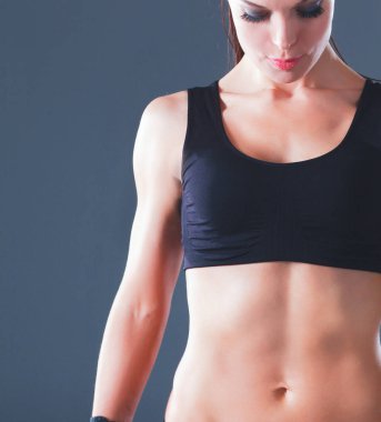 gri arka plan üzerinde duran kas genç kadın