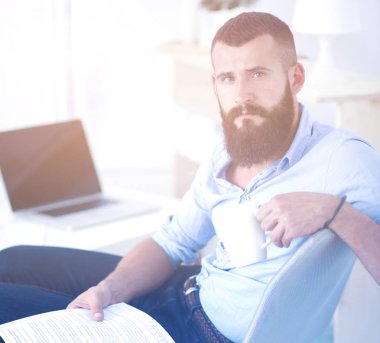 sandalye ile office kitapta oturan genç işadamı