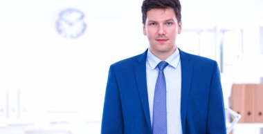 Ofiste masasının karşısında duran bir iş adamı ya da yönetici. 