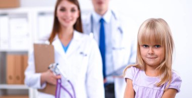 Kadın doktor ameliyatta steteskopla çocuğu muayene ediyor.