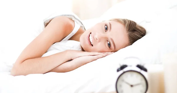 Pretty woman lying down on her bed at home — Stock Photo, Image