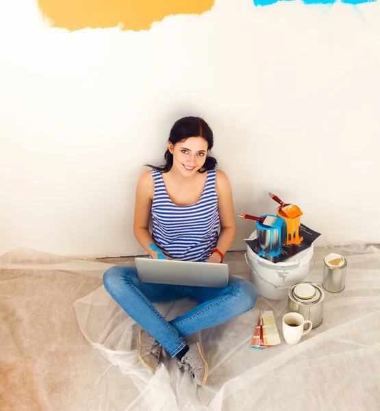 ノート パソコンに座っての新しいアパートを描きながら若い女性の肖像画 — ストック写真