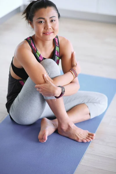 Portret uśmiechający się joga kobieta siedzi po treningu jogi maty do jogi — Zdjęcie stockowe