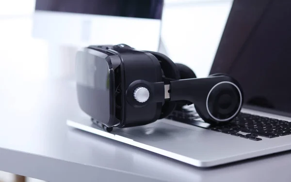 Virtual reality goggles on desk with laptop — Stock Photo, Image