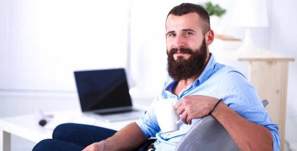 Jungunternehmer sitzt auf Stuhl im Büro — Stockfoto