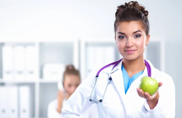 一位女医生手拿着一个绿色的苹果，站 — 图库照片