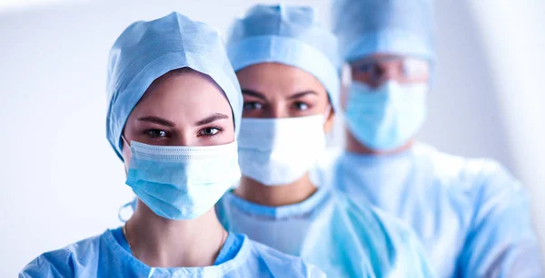 Команда хирургов в защитной форме, шапках и масках — стоковое фото