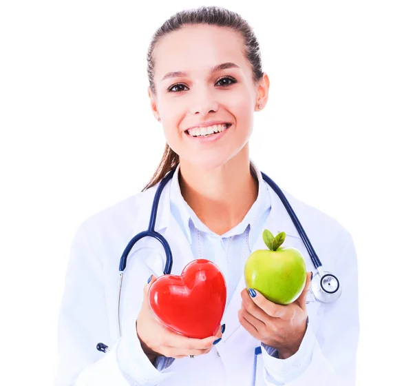 Hermosa doctora sonriente sosteniendo corazón rojo y manzana verde —  Fotos de Stock