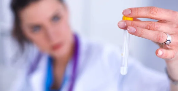 Vrouwelijke onderzoeker is omringd door medische flesjes en kolven — Stockfoto