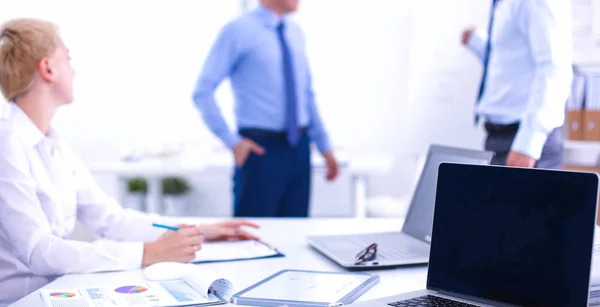 Schöne junge Geschäftsleute mit Kollegen, die im Hintergrund diskutieren — Stockfoto