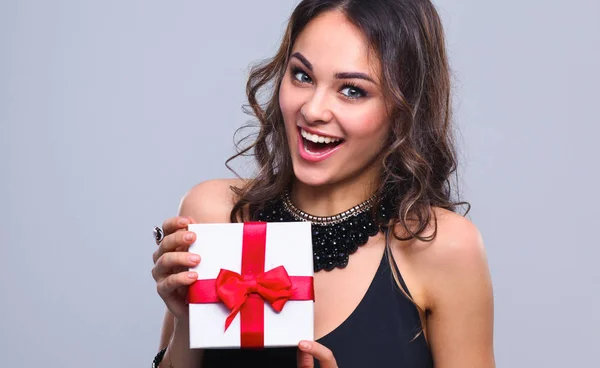 Young woman happy smile hold gift box in hands, isolated over grey background — Stock Photo, Image