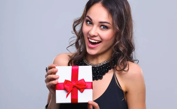 Mujer joven sonrisa feliz celebrar caja de regalo en las manos, aislado sobre fondo gris —  Fotos de Stock