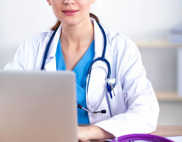Ung kvinnlig läkare studerar röntgenbild sitter på skrivbordet — Stockfoto