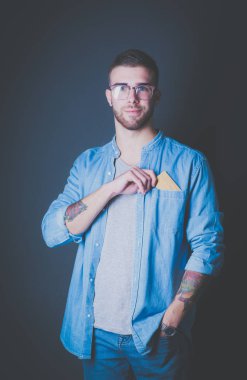 Elinde kredi kartı olan bir adam gri arka planda duruyor.