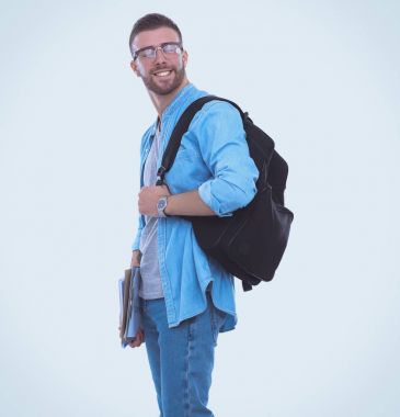 Okul çantası beyaz arka plan üzerinde izole kitap holding ile genç erkek öğrenci