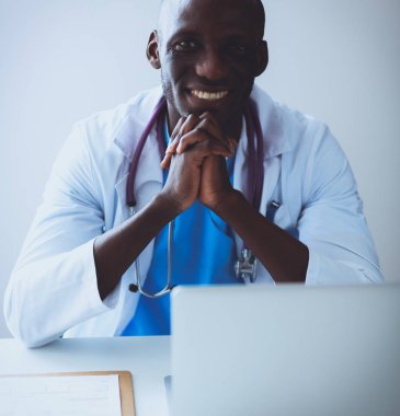 Masada dizüstü bilgisayarda çalışan genç bir Afrikalı doktor.