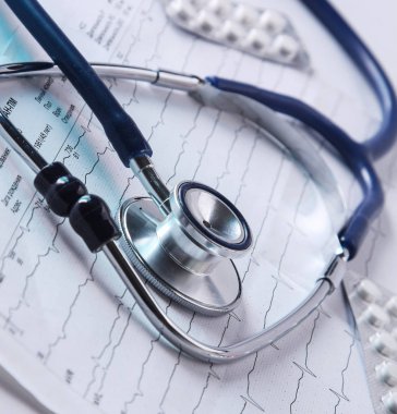 Kardiyogramda yığınla tıbbi steteskop var.