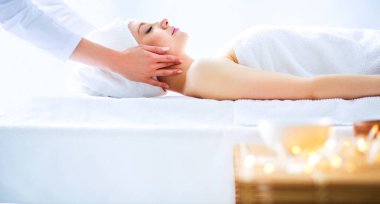 Gözleri kapalı rahatlatıcı bir masaj masanın üzerinde yatan genç kadın