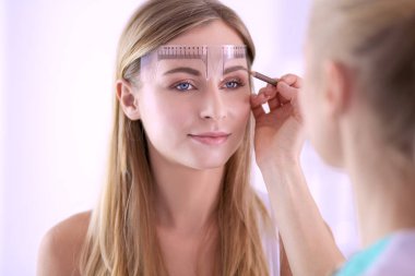 Kaşlar için kalıcı makyaj. Güzellik salonunda kalın kaşlı güzel bir kadın.