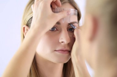 Kaşlar için kalıcı makyaj. Güzellik salonunda kalın kaşlı güzel bir kadın.