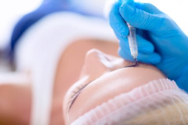 Kaşlar için kalıcı makyaj. Güzellik salonunda kalın kaşlı güzel bir kadın.