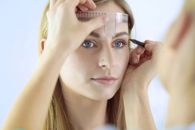 Kaşlar için kalıcı makyaj. Güzellik salonunda kalın kaşlı güzel bir kadın.