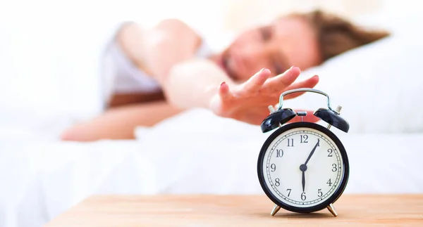 Young sleeping woman and alarm clock in bedroom at home — Stock Photo, Image