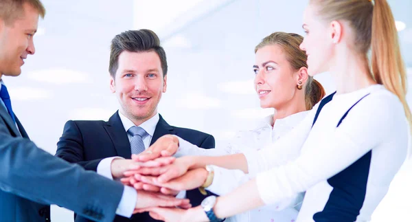 Equipe de negócios unindo as mãos em pé no escritório — Fotografia de Stock
